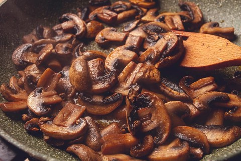 Fried mushrooms in a frying pan, with a wooden fork, homemade, no people