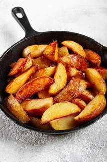 Fried potato slices, in a cast-iron pan, homemade, no people