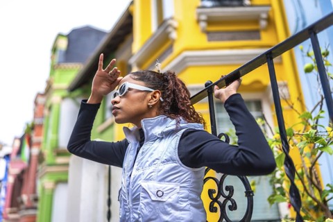 Side view of a beauty young modern african american woman covering eyes to look forward outdoors