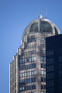A close-up view of a modern skyscraper in New York featuring a unique circular rooftop with metal