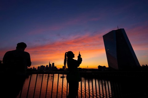 The light of the setting sun colours the sky behind the European Central Bank (ECB) and the