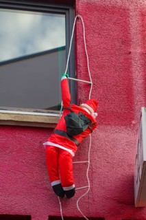 Santa Claus, red Santa Claus costume, façade climber, doll climbing rope ladder, fairy lights,