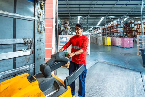 Horizontal photo with copy space from inside a vehicle of a latin man loading boxes of a delivery