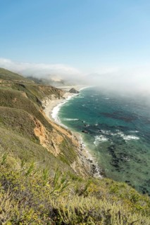 Stunning Big Sur coastline with towering cliffs, green landscapes and the waves of the Pacific