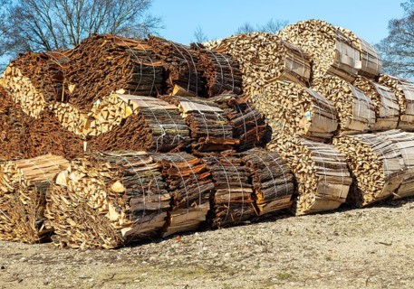 Bundles of wood offcuts and bark at a willow sawmill, Suffolk, England, UK