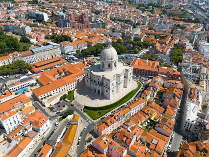 Aerial view of a city with a large domed building in the centre and red roofs, buildings, a bridge