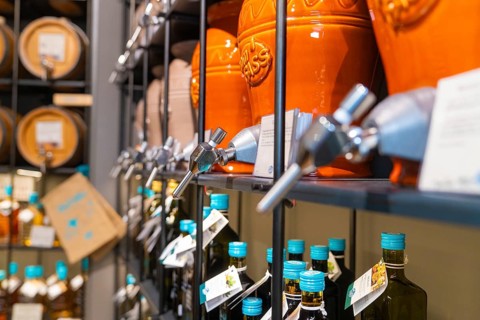 Clay pots with taps on shelves with bottles in a drinks shop, Sindelfingen, Germany