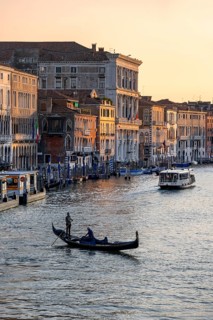 View of the Grand Canal with gondoliers at sunset, picturesque evening mood with palazzos on the