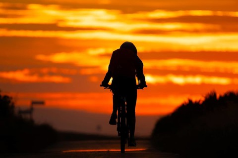 A cyclist rides towards the sunrise, Frankfurt am Main, Hesse, Germany