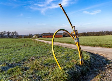 Fibre optic connection, empty conduits protrude from the ground along a dirt track, into which the