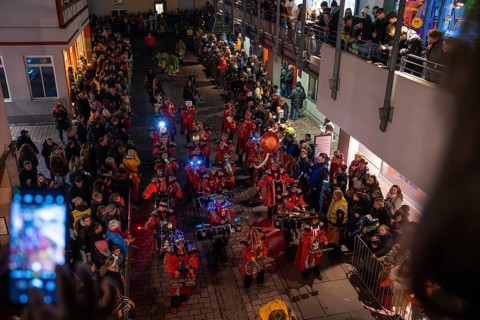 Music band in red uniforms at a night-time street party with many spectators, carnival, Calw, Black