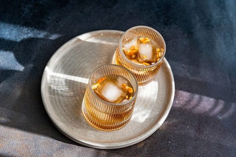 Top view of two spiced cognac based cocktails with cinnamon and star anise, served on a textured