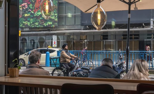 View through the window of a café of passers-by on Friedrichstraße in Mitte, Berlin, Germany