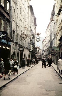 People shopping city centre alleyway of Getreidegasse, prominent guild sign for Wirtshausschild
