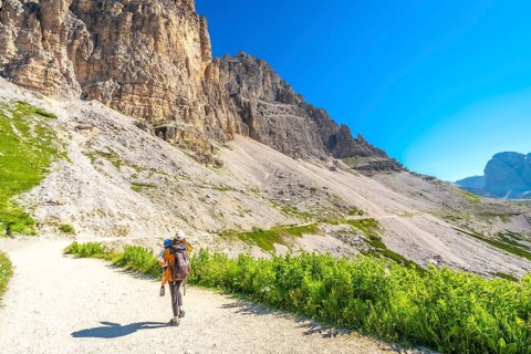 Hikers enjoying a summer trek amidst the breathtaking peaks of tre cime di lavaredo in the italian