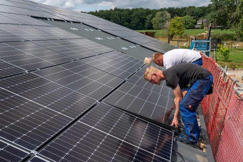Installation of solar modules on the roof of a barn on a farm, over 210 photovoltaic modules are