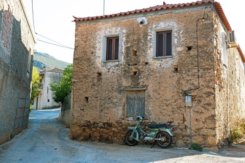 Moped at a morbid house in Agios Nikolaos, Laconia, Peloponnese, Greece
