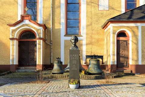Bust of Karl May with biographical data and inscription Es sei Friede, in front of the Trinitatis