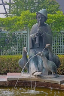 Goose keeper by Fidelis Bentele 1985, fountain with flute player and three goose figures, modern