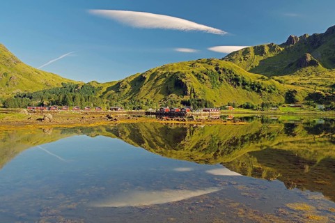 Wooden houses reflected in shallow fjord water, holiday cabins, Brustranda Sjøcamping, Valberg,