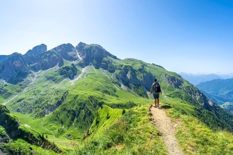 Tourist admiring breathtaking panorama in the dolomites, enjoying summer hike along the scenic