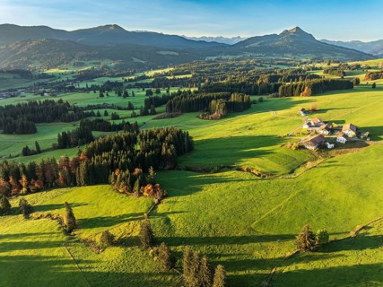 Mountain range near village Wertach, view to mt. Gruenten, sunrise, fog in valley, traditional