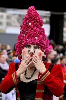 Person dressed up as a lady with a hat at the Wey guild on Rose Monday, Güdismäntig, Lucerne