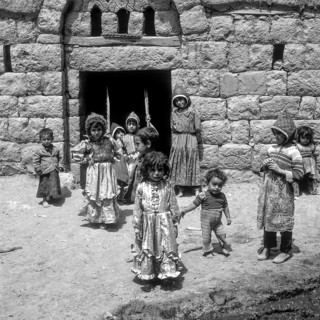 Children rocking in a house entrance, Amran, Yemen