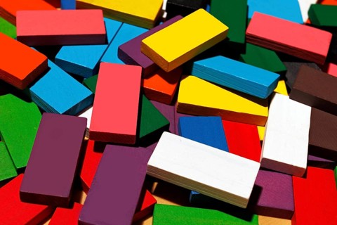 A collection of colorful wooden rectangular blocks scattered randomly. These vibrant geometric
