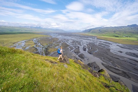 Hiker, Young woman on a hill, view over alluvial land, meandering river, Dímonarhellir, Suðurland,