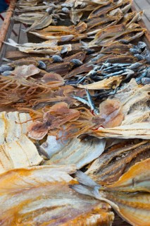 A wooden frame with various dried fish on the beach, fish drying, Praia da Nazare beach, Nazaré,