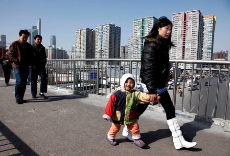 Beijing, CHN, 20.02.09 - A young Chinese mother holds her child's hand as she walks across a