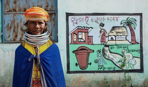 Woman from the Bonda tribe near a mural painting promoting the use of toilets (Odisha, India), a