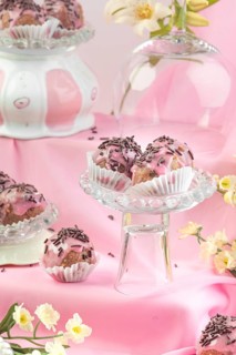 Punch balls, pink-coated chocolates on various glass plates with flower arrangements, pink