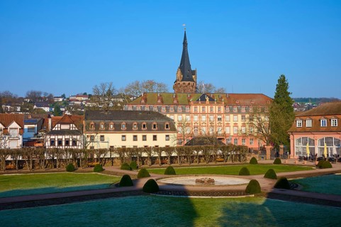 A city view with historic buildings and a central tower under a clear sky, pleasure garden, castle,