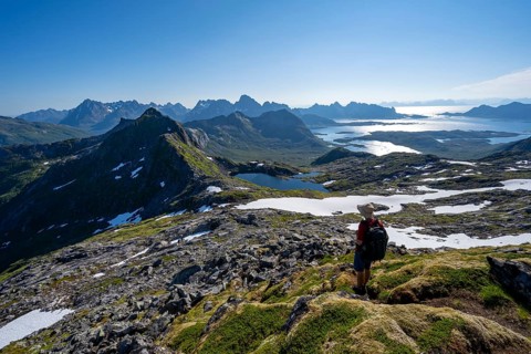 View of mountains and fjord landscape, mountaineers at the summit of Rundfjellet, Austenesfjord and