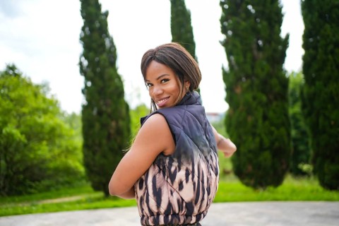 Cute female latin sensual beauty dancer turning to smile at camera dancing salsa alone in an urban