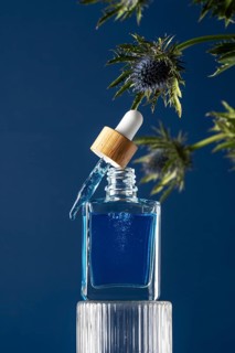 A premium men's face care serum showcased in a glass dropper bottle with a cooling effect, perfect