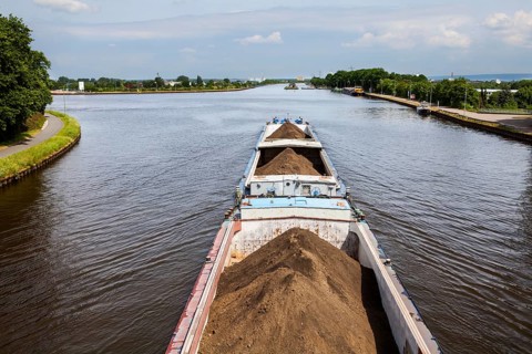 A towboat pushes a loaded barge in Minden, Mittelland Canal to Minden Aqueduct, Minden, North