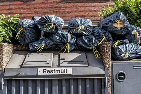 Full residual waste container, private household, apartment block, additional rubbish bags from the
