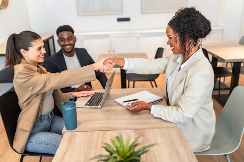 Businesswomen shaking hands after reaching an agreement during a meeting in a modern office,