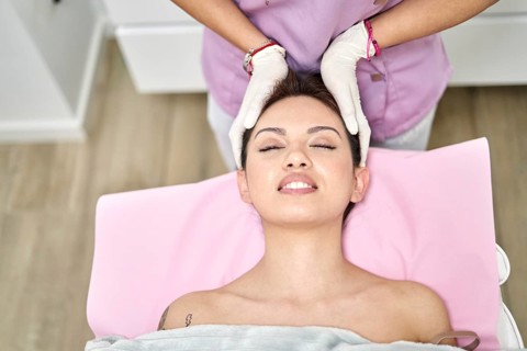 A skilled practitioner provides a soothing head massage to a client in a beauty salon. The serene