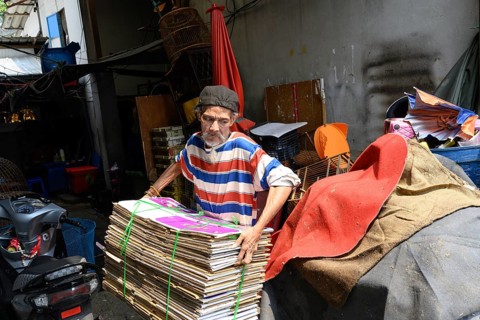 Bangkok, Thailand. February 19th 2025. A man collecting recycled cardboard at the Khlong Toei