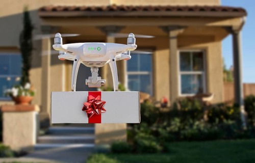 Unmanned UAV quadcopter drone delivering box with red bow and ribbon to house.