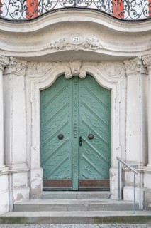 Elegant mint green door in baroque style with intricate decorations in the historic old town of
