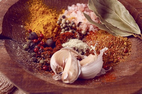 Spice mix, garlic and bay leaf, on a wooden plate, close-up, food concept, no people