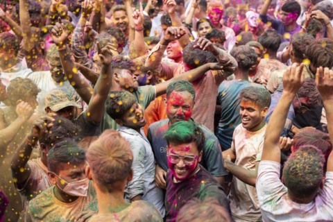 Revellers dancing in the beat of music as they celebrate Holi on a street, the Hindu spring