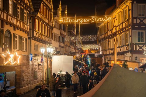 Busy street with Christmas market stalls in a picturesque old town at night, Christmas market Calw,