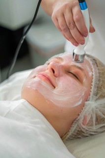 A client enjoys a rejuvenating RF lifting procedure with a specialist applying conductive gel and a
