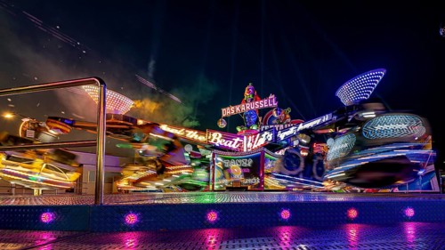 Moving, colorful carousel at night at a lively fair, carousel and hustle and bustle of summer